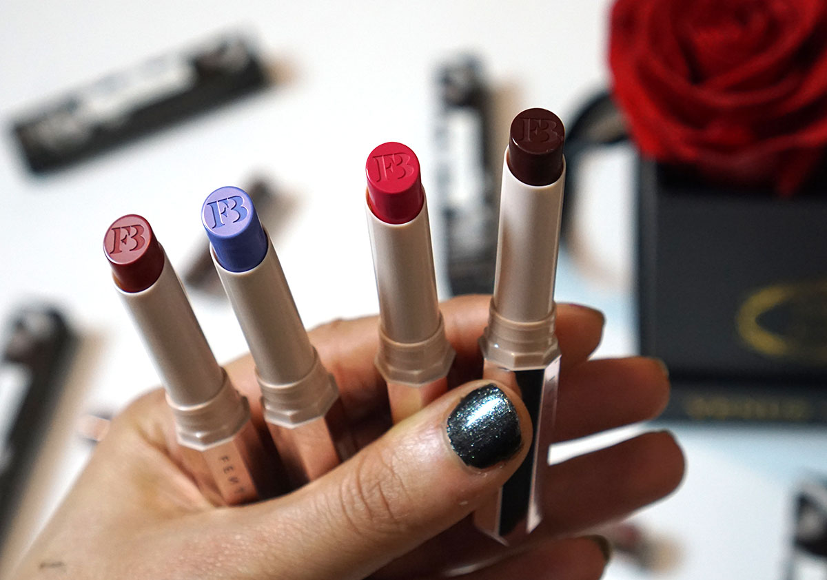 Fenty beauty matte lipstick shades MA'DAMN (royal red), GRISELDA (bold burgundy), Candy Venom (electric pink), and Ya Dig?! (periwinkle blue).